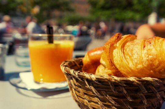 Un jus d'orange et un croissant sont posés sur un table