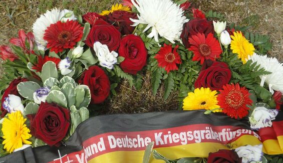 Gerbe de fleurs sur lequel est fixé un bandeau allemand